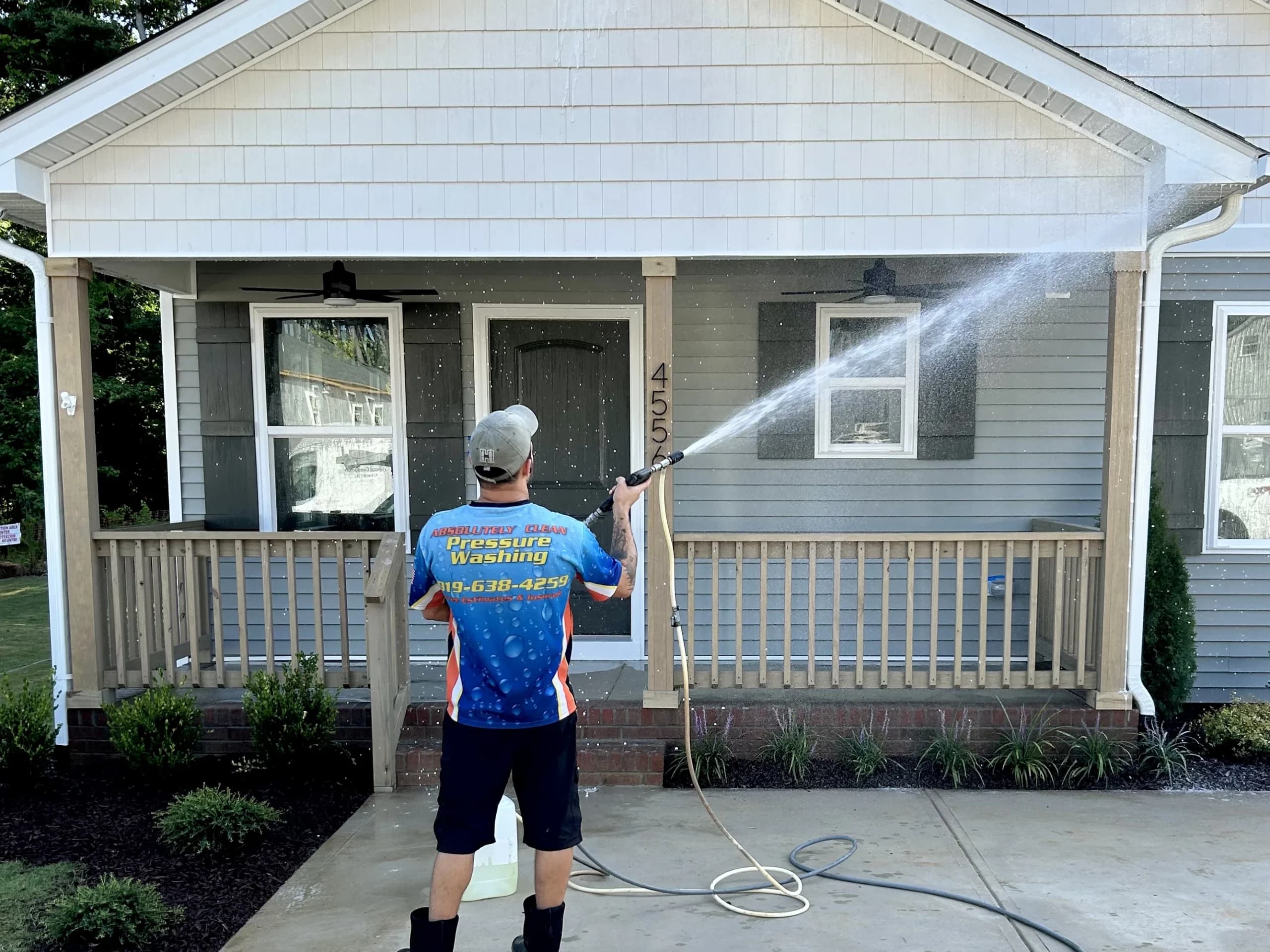 Exterior cleaning technician working on a house exterior